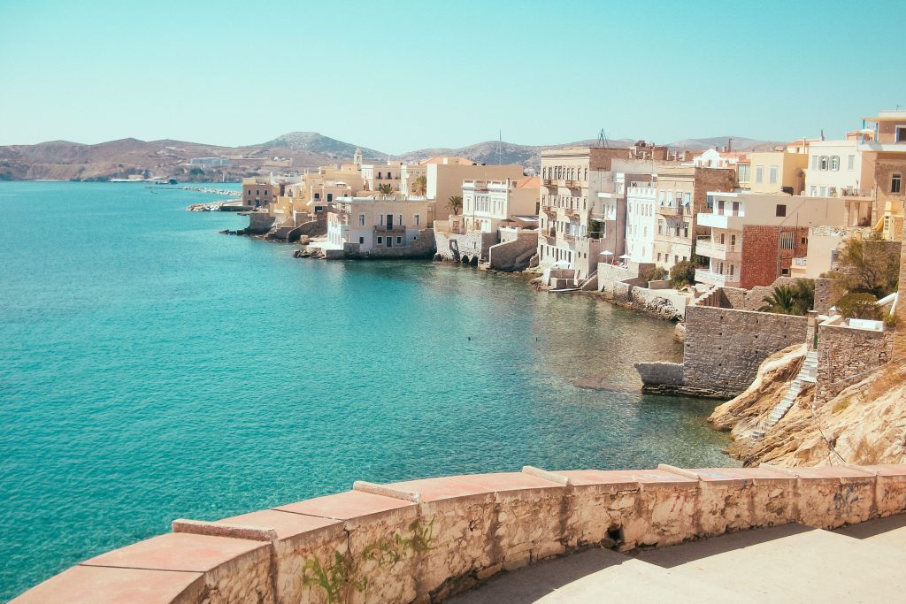 Charming seaside town with turquoise waters and Mediterranean architecture on a sunny day.