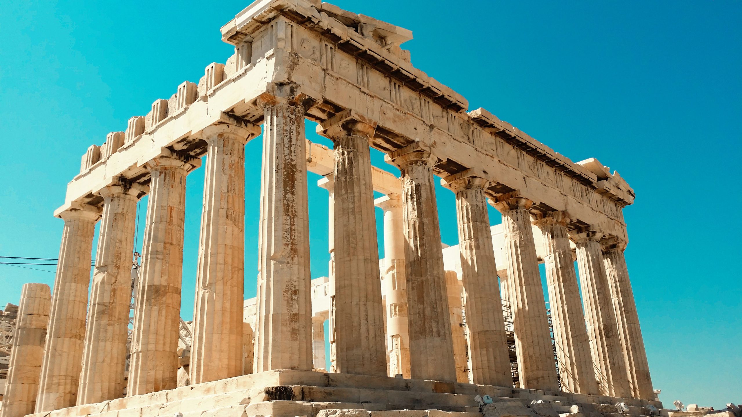 Blog Impressive view of the ancient Parthenon in Athens against a clear blue sky.